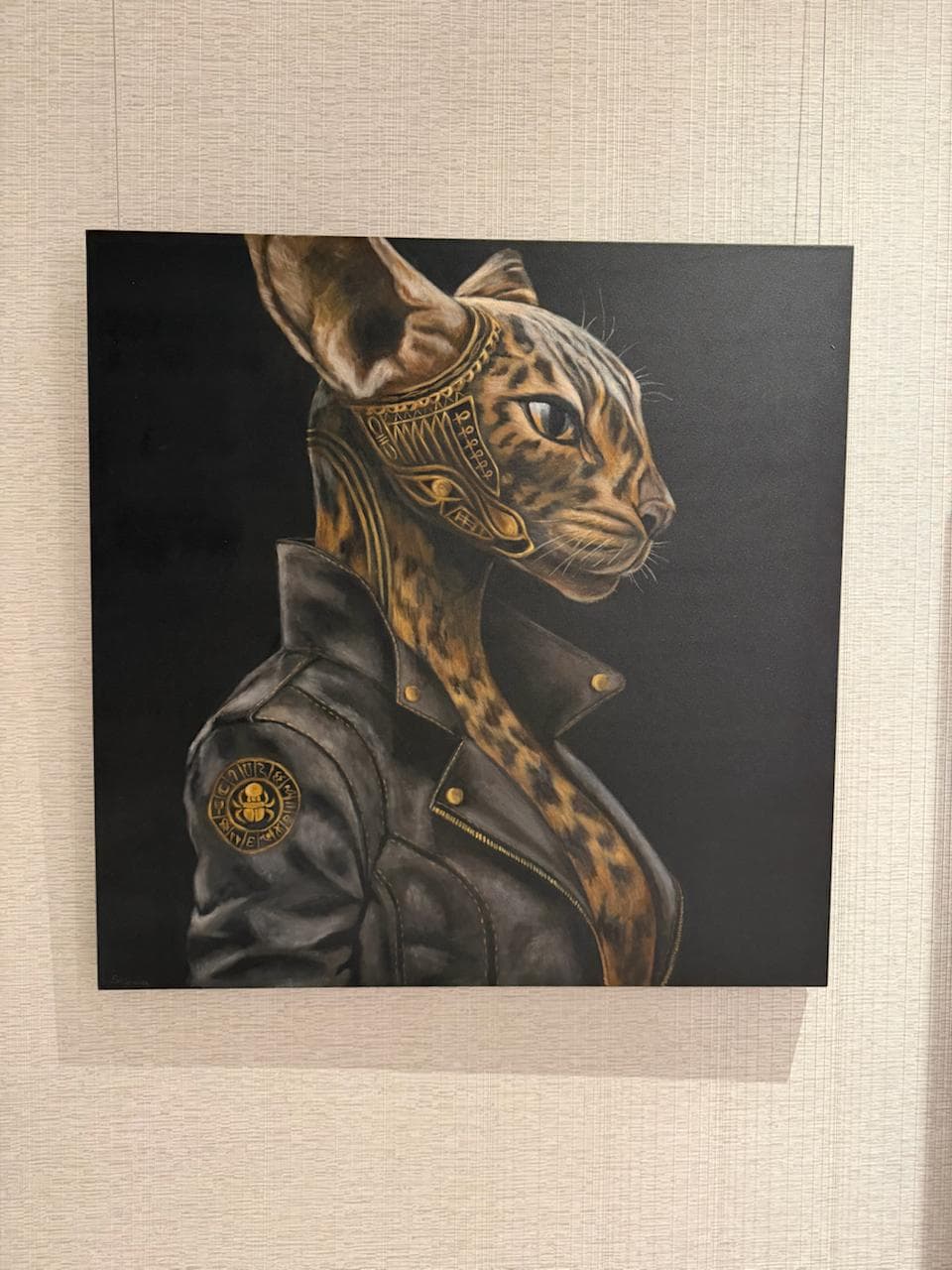 BASTET by Shimova, a framed acrylic painting of an Egyptian feline figure in a black leather jacket with gold headpiece details against a dark ground.