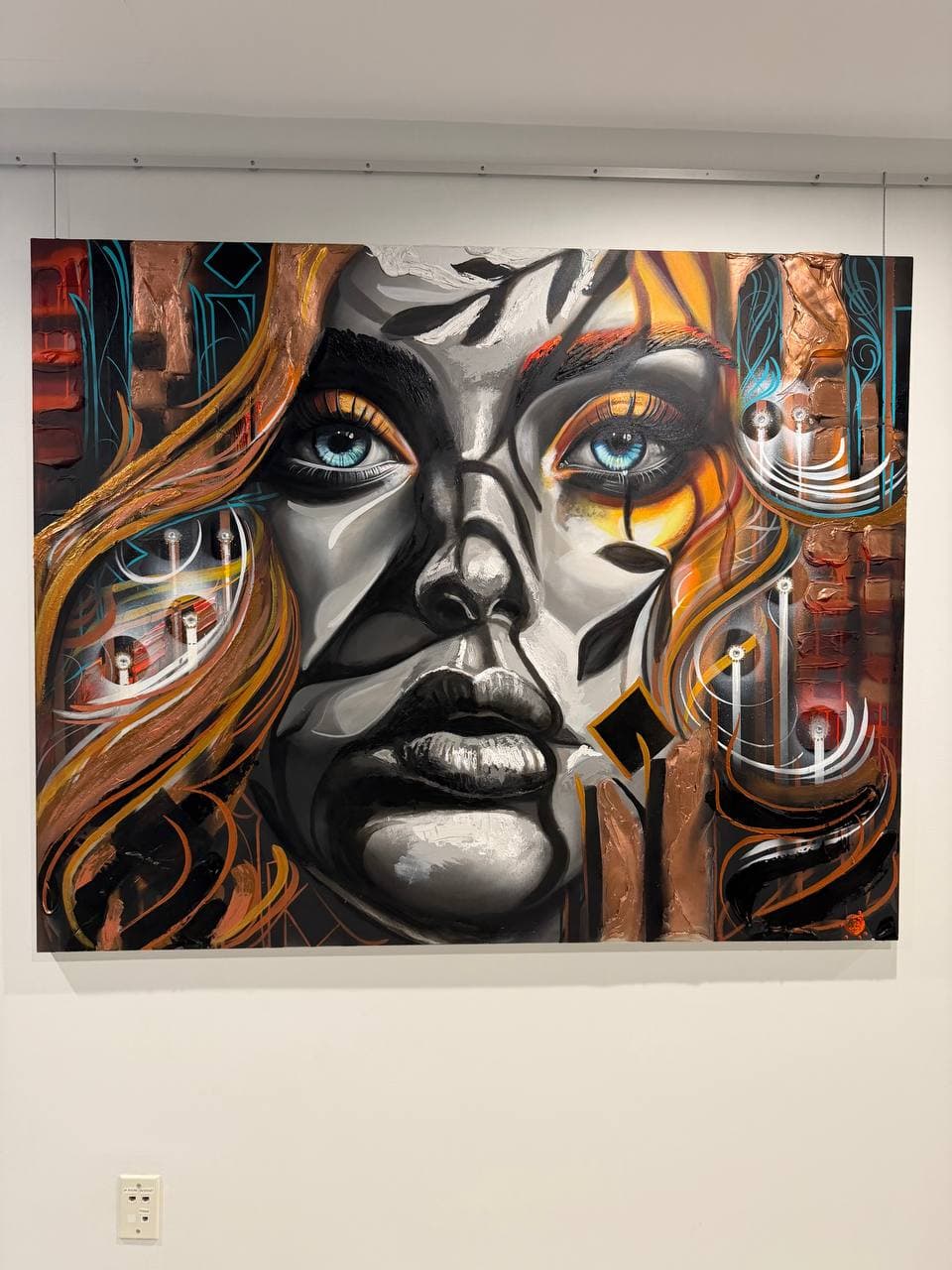 Chronodermism Glow from stillness by Rudy Hetzer, a mixed media portrait with a grayscale face, blue eyes, copper textures, brick forms, orange movement, and turquoise linework.