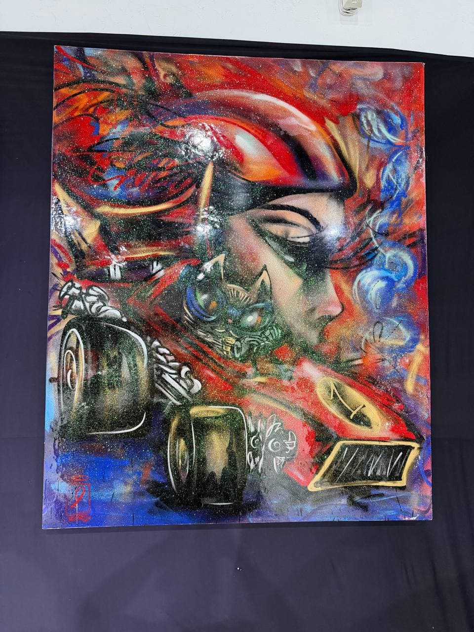 9Juane$ artwork F1 showing a red Formula-style race car with a surreal face, blue smoke, graffiti marks, and saturated motion.