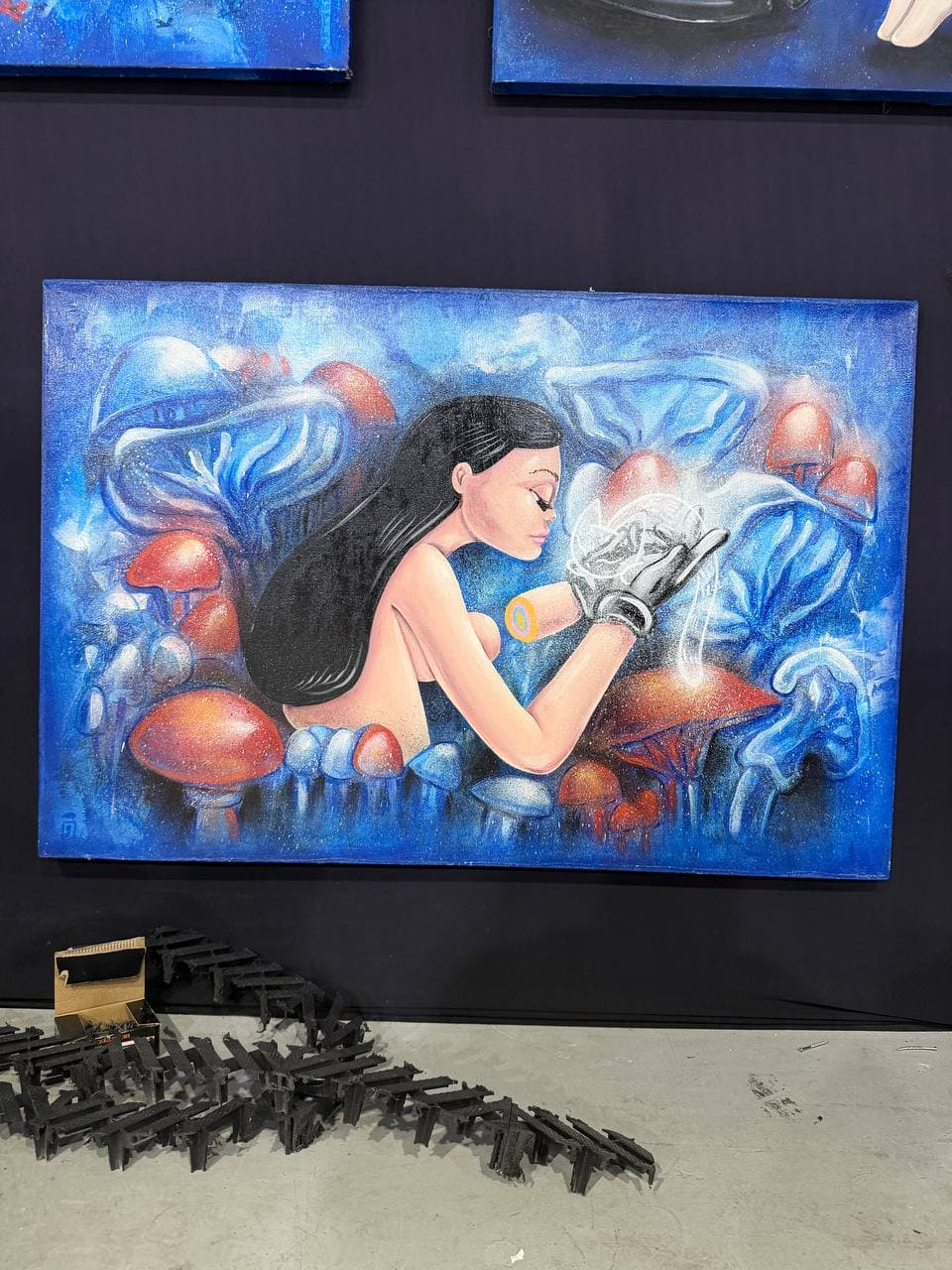9Juane$ artwork Spectrum showing a female figure in a blue mushroom dreamscape holding a glowing object with a mechanical hand.