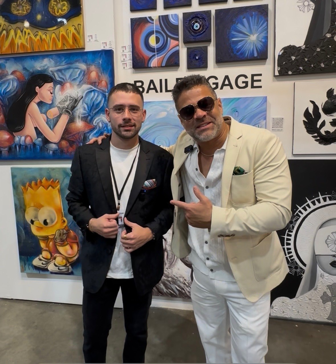 Jason Perez with an artist in front of pop art works