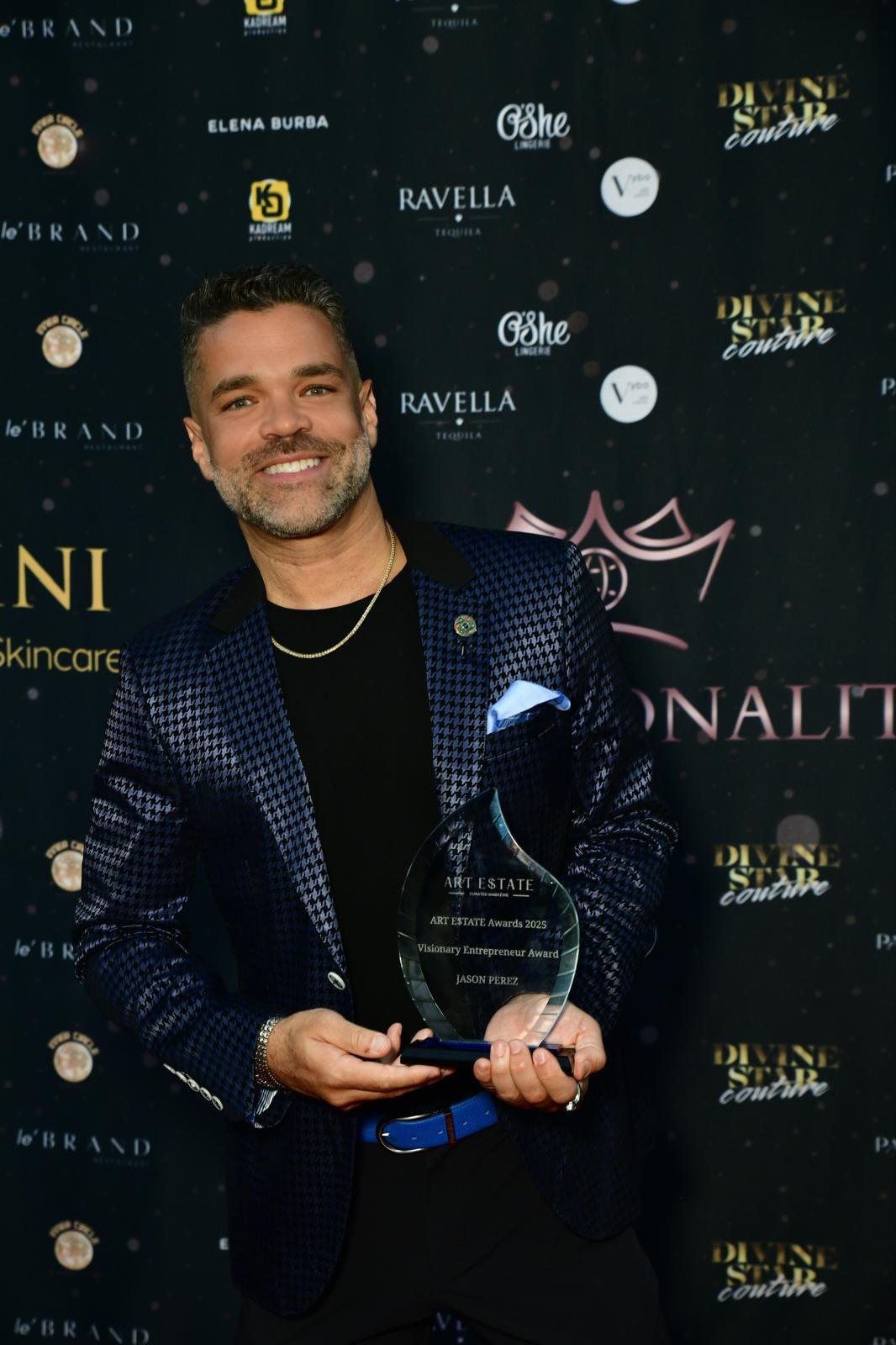 Jason Perez holding an award in front of a branded step-and-repeat backdrop