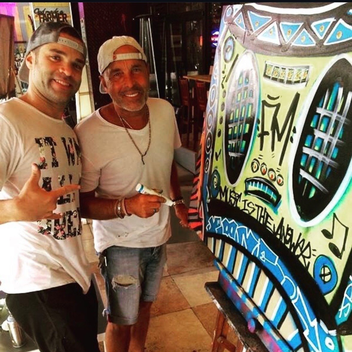 Jason Perez with Michael Perez beside colorful artwork